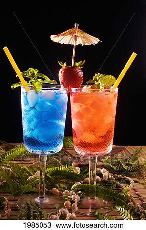 Two Tropical Drinks Garnished With Fruit And Flowers. View Large Photo Image Stock Image - Two Tropical Drinks Garnished With Fruit And Flowers.. Fotosearch
