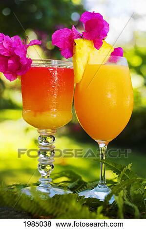Stock Photo - Two Tropical Drinks Garnished With Fruit In An Outdoor Setting.. Fotosearch