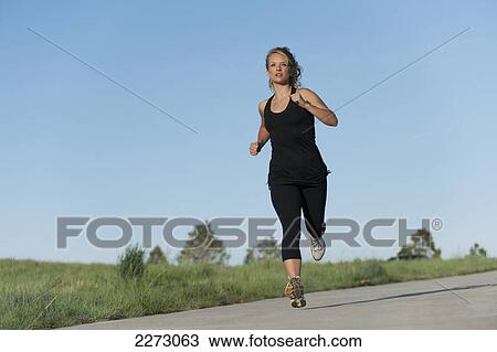 Stock Image - Woman running on a path; arvada colorado united states of america. Fotosearch