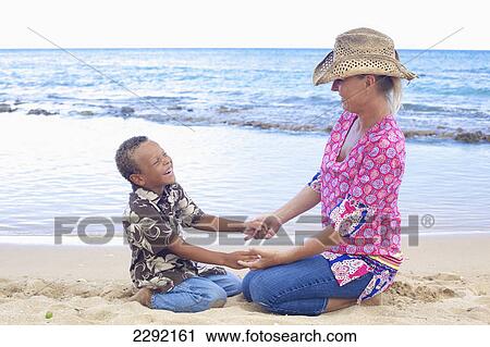 A mother and son on the beach at the water's edge; Hawaii united states of america View Large Photo Image Stock Image - A mother and son on the beach at the water's edge; Hawaii united states of america. Fotosearch