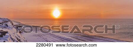 A sundog hangs in the air over the beaufort sea coast at sunset outside of barrow in winter; Alaska united states of america View Large Photo Image Stock Image - A sundog hangs in the air over the beaufort sea coast at sunset outside of barrow in winter; Alaska united states of america. Fotosearch