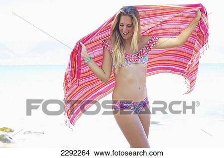 A teenage girl in a bikini holding a wrap with the ocean in the background; Maui hawaii united states of america View Large Photo Image Picture - A teenage girl in a bikini holding a wrap with the ocean in the background; Maui hawaii united states of america. Fotosearch