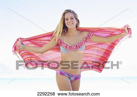 A teenage girl in a bikini holding a wrap with the ocean in the background; Maui hawaii united states of america View Large Photo Image Stock Photo - A teenage girl in a bikini holding a wrap with the ocean in the background; Maui hawaii united states of america. Fotosearch