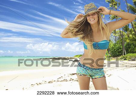 A teenage girl on the beach in a two piece bathing suit and hat; Maui hawaii united states of america View Large Photo Image Stock Photo - A teenage girl on the beach in a two piece bathing suit and hat; Maui hawaii united states of america. Fotosearch