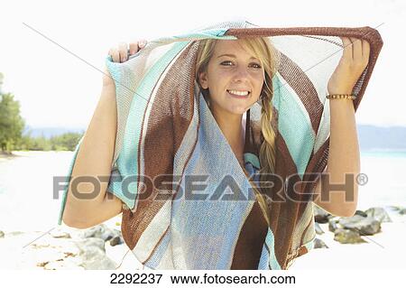 Stock Photo - A teenage girl on the beach with a swimsuit cover-up over her head; Maui hawaii united states of america. Fotosearch
