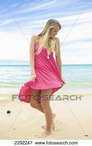 Stock Photo - A teenage girl with long blond hair poses on the beach; Maui hawaii united states of america. Fotosearch
