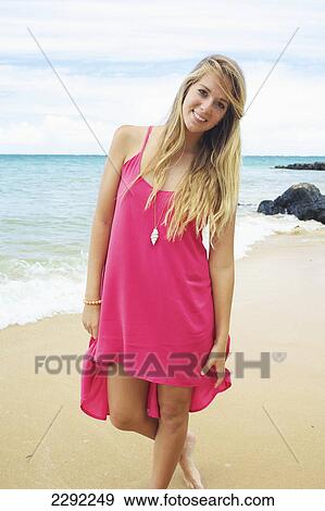Stock Photo - A teenage girl with long blond hair poses on the beach; Maui hawaii united states of america. Fotosearch
