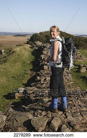 Stock Photo - A woman hikes along hadrian's wall; Northumberland england. Fotosearch