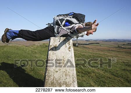 Stock Photo - A woman lays across the top of a stone structure at hadrian's wall; Northumberland england. Fotosearch