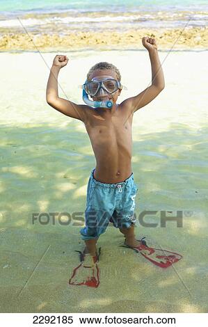 Stock Photography - A young boy in the shallow water of the ocean with snorkelling gear; Hawaii united states of america. Fotosearch