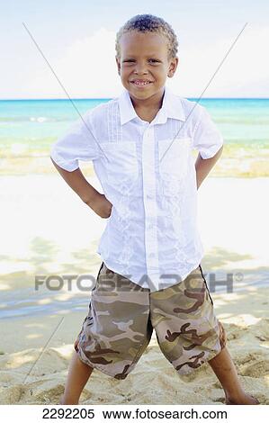 A young boy poses on a beach at the water's edge; Hawaii united states of america View Large Photo Image Stock Photography - A young boy poses on a beach at the water's edge; Hawaii united states of america. Fotosearch