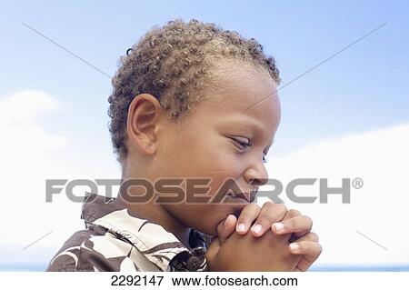 A young boy with hands folded in prayer; Hawaii united states of america View Large Photo Image Stock Photo - A young boy with hands folded in prayer; Hawaii united states of america. Fotosearch