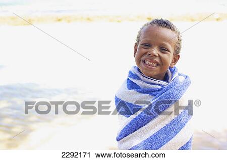 A young boy wrapped up in a towel on the beach; Hawaii united states of america View Large Photo Image Stock Image - A young boy wrapped up in a towel on the beach; Hawaii united states of america. Fotosearch