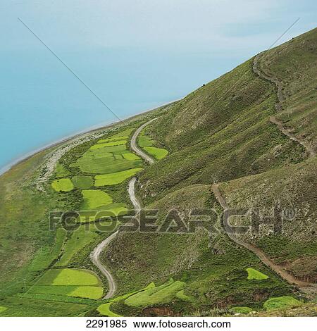 Stock Photography - Aerial view of the landscape with fields and a road across the hills; Shannan xizang china. Fotosearch