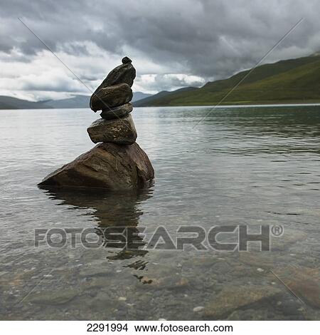 Picture - Cairn sitting in the shallow water along the shoreline of sacred lake; Shannan xizang china. Fotosearch