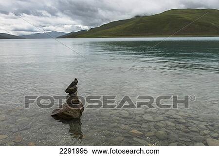 Stock Photography - Cairn sitting in the shallow water along the shoreline of sacred lake; Shannan xizang china. Fotosearch