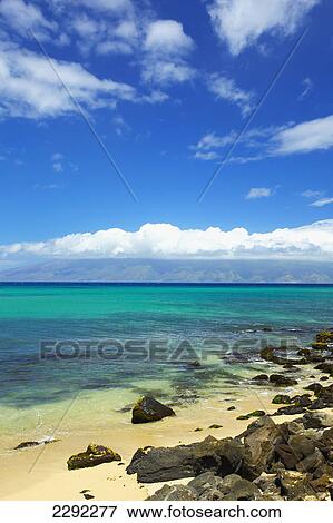 Stock Photo - Coastline of an hawaiian island with a sandy beach in the foreground and mountains in the background; Hawaii united states of america. Fotosearch