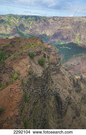 High angle view of rugged mountains and a valley under a cloudy sky; Hawaii united states of america View Large Photo Image Picture - High angle view of rugged mountains and a valley under a cloudy sky; Hawaii united states of america. Fotosearch