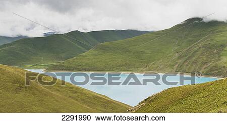 Hilly landscape and sacred lake under a cloudy sky; Shannan xizang china View Large Photo Image Stock Image - Hilly landscape and sacred lake under a cloudy sky; Shannan xizang china. Fotosearch
