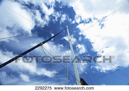 Stock Photography - Low angle view of a boat mast against a blue sky with cloud; Hawaii united states of america. Fotosearch