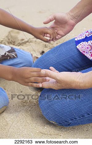 Stock Image - Mother and son holding hands; Hawaii united states of america. Fotosearch