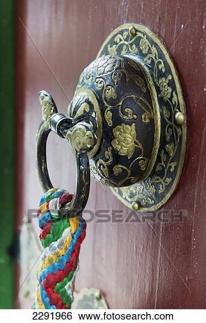 Stock Photograph - Ornate doorknob with colourful fabric hanging from the ring; Lhasa xizang china. Fotosearch