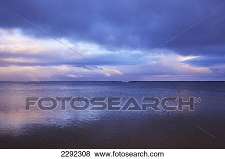 Stock Photo - Pink sunlight reflected on the tranquil water at sunset; Hawaii united states of america. Fotosearch