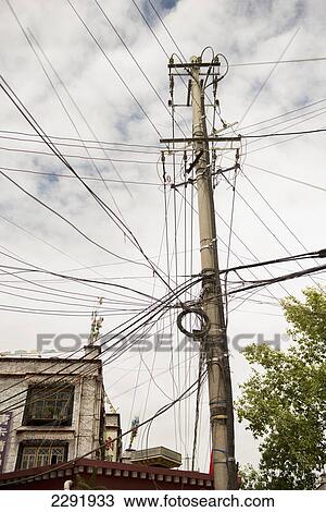Stock Image - Pole overloaded with power lines; Lhana xizang china. Fotosearch