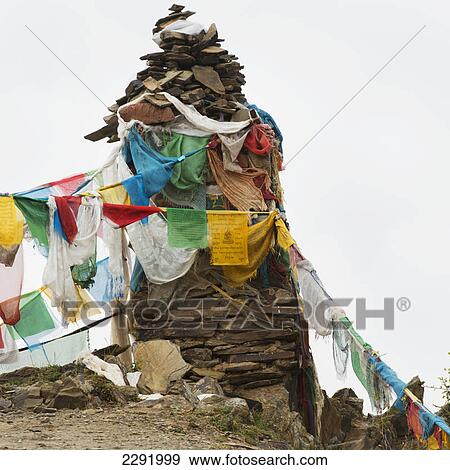 Stock Photo - Prayer flags hanging from a cairn; Shannan xizang china. Fotosearch