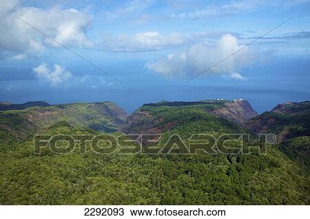 Rugged landscape of mountains covered with trees under a cloudy sky; Hawaii united states of america View Large Photo Image Stock Image - Rugged landscape of mountains covered with trees under a cloudy sky; Hawaii united states of america. Fotosearch