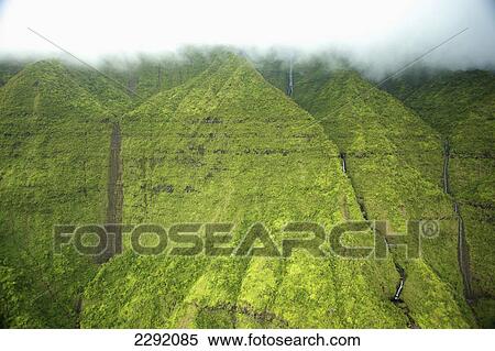 Streams flowing down a lush green mountainside with low lying cloud; Hawaii united states of america View Large Photo Image Stock Photography - Streams flowing down a lush green mountainside with low lying cloud; Hawaii united states of america. Fotosearch
