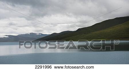 Tranquil water of sacred lake under a cloudy sky; Shannan xizang china View Large Photo Image Stock Photograph - Tranquil water of sacred lake under a cloudy sky; Shannan xizang china. Fotosearch