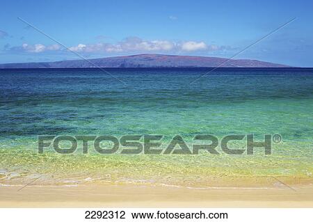 Stock Image - View of the mountains on an hawaiian island from the sandy shore; Hawaii united states of america. Fotosearch