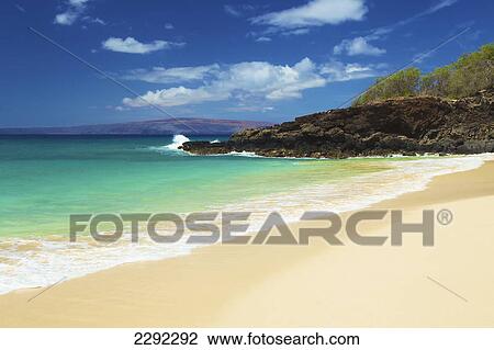 Stock Image - Water washing up on the sandy beach along the coastline of an hawaiian island; Hawaii united states of america. Fotosearch