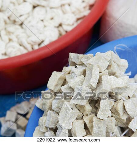 Stock Image - White rocks in a blue bowl sitting beside a red bowl; Lhasa xizang china. Fotosearch