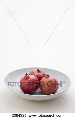 Stock Photography - 3 Pomegranates In Low Bowl. Fotosearch