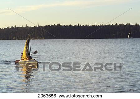 Stock Photograph - 45 Year Old Woman Kayaking On Clear Lake; Canada, Manitoba, Riding Mountain National Park. Fotosearch
