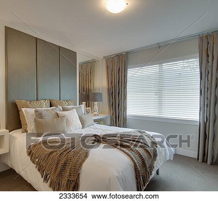 A bed in a bedroom decorated with cushions and a blanket; Surrey, British Columbia, Canada View Large Photo Image Picture - A bed in a bedroom decorated with cushions and a blanket; Surrey, British Columbia, Canada. Fotosearch