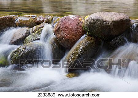 A close up of water in a river spilling over rocks; Maui, Hawaii, United States of America View Large Photo Image Stock Photo - A close up of water in a river spilling over rocks; Maui, Hawaii, United States of America. Fotosearch