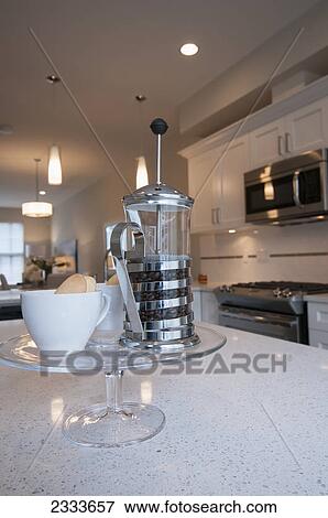 A coffee press with coffee beans and cups with cookies on a tray in the kitchen; Surrey, British Columbia, Canada View Large Photo Image Stock Photo - A coffee press with coffee beans and cups with cookies on a tray in the kitchen; Surrey, British Columbia, Canada . Fotosearch