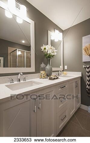 Stock Image - A contemporary bathroom with double sinks and white cabinets; Surrey, British Columbia, Canada. Fotosearch