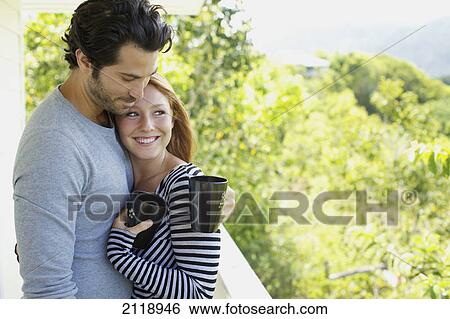 Stock Photograph - A Couple On A Balcony With Their Coffee Mugs; Wailua Kauai Hawaii United States Of America. Fotosearch