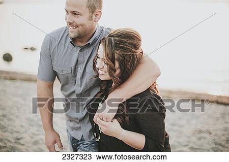 Stock Image - A couple walking on a beach; White rock british columbia canada. Fotosearch
