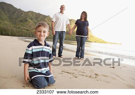 A family poses for a portrait on a beach; Oahu hawaii united states of america View Large Photo Image Stock Photo - A family poses for a portrait on a beach; Oahu hawaii united states of america. Fotosearch