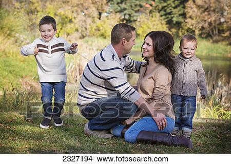 Picture - A family spending quality time together in the park in autumn; St. albert alberta canada. Fotosearch