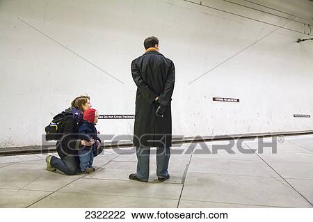 Stock Image - A father mother and young son wait for the max train at the underground washington park stop (zoo); Portland oregon united states of america. Fotosearch