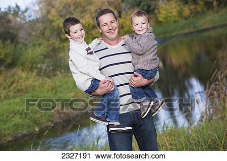 Stock Image - A father with his two young sons in a park in autumn; St. albert alberta canada. Fotosearch