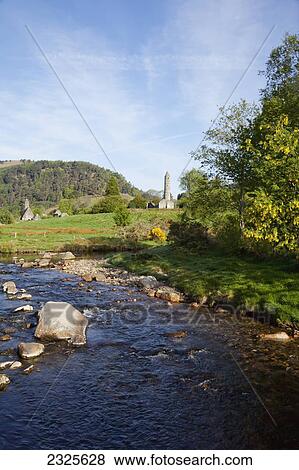 A flowing creek with a round tower in the distance; Glendalough county wicklow ireland View Large Photo Image Stock Photo - A flowing creek with a round tower in the distance; Glendalough county wicklow ireland. Fotosearch