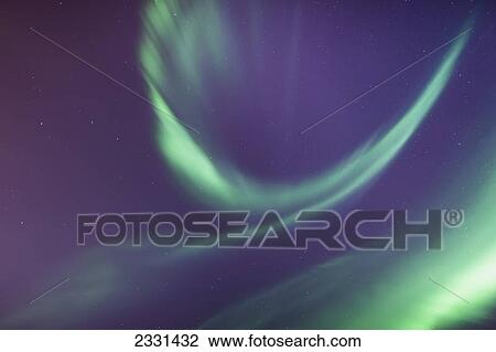 Stock Image - A green northern lights corona in the sky above the tony knowles coastal trail in winter; Anchorage alaska united states of america. Fotosearch