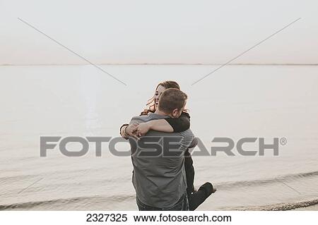 A man and woman in an embrace at the water's edge; White rock british columbia canada View Large Photo Image Stock Photography - A man and woman in an embrace at the water's edge; White rock british columbia canada. Fotosearch